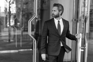 CEO ofise giriyor. İş adamı. Başarılı bir iş adamı ofise giriyor. Olgun girişimci ofis kapısı. Takım elbiseli Amerikalı işadamı ofis binasını terk ediyor. Nüfuzlu iş adamı.