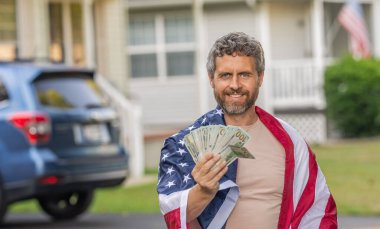 Vatansever adam. Amerikan bayrağı ve dolar parası olan adam. Enflasyon konsepti. Amerikan vergi politikası. İspanyol adam ve Amerikan bayrağı. Amerika 'da vergi ödemek. Katma değer vergisi. Vergilendirme sistemi pankartı.