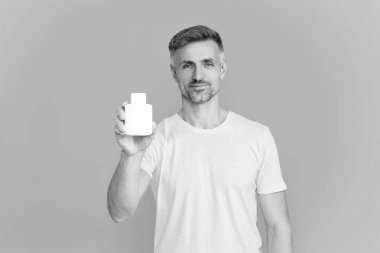 Haplı ya da vitaminli bir adam. Enerji ilacını sunuyorum. Multivitamin ve vitamin. Günlük takviye. İlaç teklif et. Acıyı dindirmek için ilaç. İnsan maviden yiyecek desteğini ayırır. İlaç..