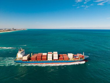 Kargo işi. Konteyner gemisi. Nakliye lojistiği. Ticari nakliye. Kargo gemisi denizde, insansız hava aracı manzaralı. Yük konteynırı kargo gemisine yüklendi. Deniz manzaralı kargo gemisi.