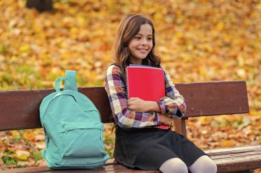 Öğrenci kız sonbaharda ödev yapar. Çalışmak için sonbahar zamanı. Liseli kız dışarıda bilgi topluyor. Bilgi toplama günü. Sonbahar günü. Okula dönelim. Eğitim ve bilgi. Okul eğitimi. Kaydı aç.