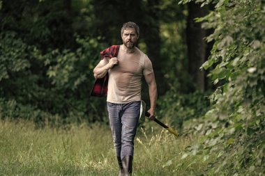 Baltalı yakışıklı bir adam. Ormanda baltayla oduncu. Keresteci gömlekli ve baltası ağır. Güçlü adam ormanda çalışır. Oduncu ormanda balta taşıyor. Oduncu çok çalıştıktan sonra terliyor.