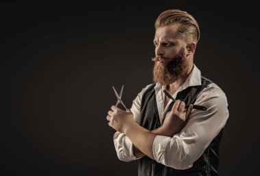 Saç keserken makas ve retro bıçak kullanan yakışıklı berber. Modern berber saç kesimi. Siyah sakallı hippi berber. Berberdeki kuaförden sakal kesimi. Boşluğu kopyala.