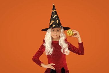 Cadılar Bayramı 'nda balkabağı. Cadıların Cadılar Bayramı kostümü. 31 Ekim balkabağı. Kostüm partisi. Cadılar Bayramı balkabağı cadı kızın elinde. Cadılar Bayramı cadısı, turuncu üzerine izole edilmiş. Balkabağı feneri..