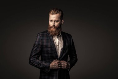 Bespoke takımı. Özel dikim erkek giysisi giymiş sakallı adam. Özel dikim kıyafet giyen bir iş adamı. Şık takım elbiseli bir iş adamı. Resmi terzilik kıyafeti. Erkek giyim kuşamı. Moda anlayışı.