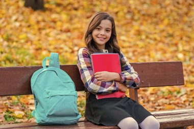 Çalışmak için sonbahar zamanı. Liseli kız dışarıda bilgi topluyor. Bilgi toplama günü. Sonbahar günü. Okula dönelim. Eğitim ve bilgi. Okul eğitimi. Öğrenci kız sonbaharda ödev yapar. Üniversiteye kayıt ol..