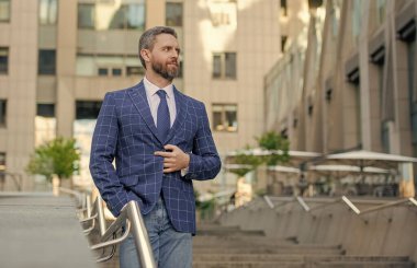 Takım elbiseli zengin adam. Finansal bölge. Ticari başarı hırslı bir adam. İş görüşmelerinden sonra şehirde başarılı bir iş adamı. İş adamının iş başarısı. Resmi takım elbiseli bir iş adamı..