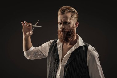 Makas kullanan berber. Kaba kuaför saç kesiyor. Berber dükkanında çalışan bir kuaför. Berber dükkanı. Kızıl sakallı adam. Berber dükkanındaki kuaför siyahlara bürünmüş..