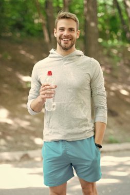 Sıvı yeterliliği. Susuz kalma. Susamış sporcu. Adam maden suyu tutuyor. Susadım. Plastik şişeli genç bir adam. Sağlıklı bir yaşam tarzı. Vücutta su dengesi. Umutsuzca bir yudum.