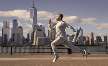 Sporcu adam aktif giyinmek için koşuyor. Sporcu koşucu. Manhattan 'da spor habercisi. New York 'a doğru koşan sporcu. Pankart.