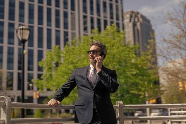 Takım elbiseli bir adam telefonda konuşuyor. Telefonu olan orta yaşlı İspanyol işadamı. İş iletişimi. İş adamının dışarıyı araması gerekiyor. Telefon kullanan bir iş adamı. Toplantı tutanakları.