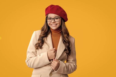 Kız sonbaharda şık görünüyor. Gençlik modelinin sonbahar havası. Sonbahar moda kızı sarıda izole edilmiş. Moda ve şık bir kız. Gözlüklü ve bereli sonbahar kızı. Sonbahar sezonu. Dış giysi beyanı.