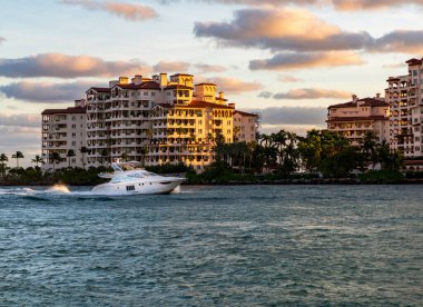 Marinaya yüzen bir tekne. Fisher Adası 'nda lüks bir yat teknesi. Yaz tatili. Fisher Adası konut binası ve lüks yat teknesi. Miami Fisher Adası Panorama Manzarası.