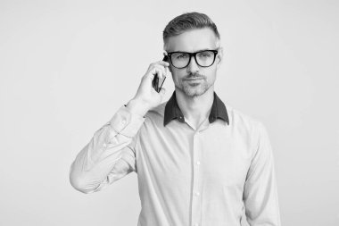 İş adamının Grey 'den izole edilmiş bir telefon görüşmesi var. Telefon kullanan bir iş adamı. Gözlüklü bir adam telefonda konuşuyor. Telefonu olan olgun bir iş adamı. İş iletişimi. Boşluğu kopyala.