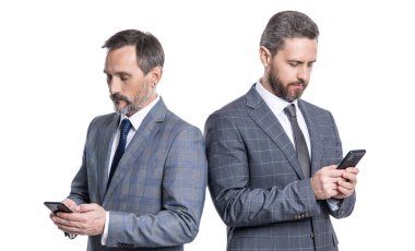 Takım elbiseli iş adamları telefon kullanır. Blogda sohbet eden iki iş adamı. Telefondaki mesajlaşan iş adamları beyazdan izole edilmiş. İş mesajlaşması. İnternet işi. Mesaj gelen kutusu.
