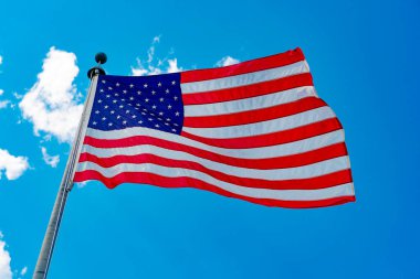 Amerikan bayrağı bağımsızlık günü için dalgalanıyor. ABD bayrağı. Mavi gökyüzünde Birleşik Devletler bayrağı sallıyor. Bağımsızlık Günü. Vatanseverlik sembolü. Anma Günü veya 4 Temmuz 'da Amerikan Bayrağı.