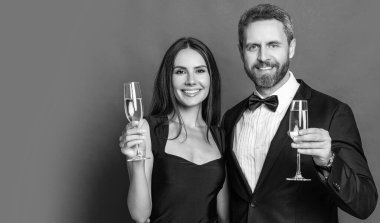 Resmi olarak bir çift. Romantik randevu kutlamaları. Sevgililer Günü. Yıldönümünü kutlayalım. Aşık çift nişanı kutluyor. Zarif çift kırmızı pankartta izole edilmiş şampanya içiyor..