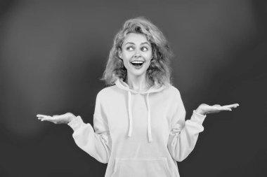 Yaşam tarzı konsepti. Kapüşonlu kadın model. Çekici bir kadının şık bir görünüşü var. Kız havalı görünüyor. Minimum giysi. Pembe üzerine izole edilmiş kapüşonlu günlük kıyafetler giyen kızıl saçlı kadın. Ürünü sunuyorum..