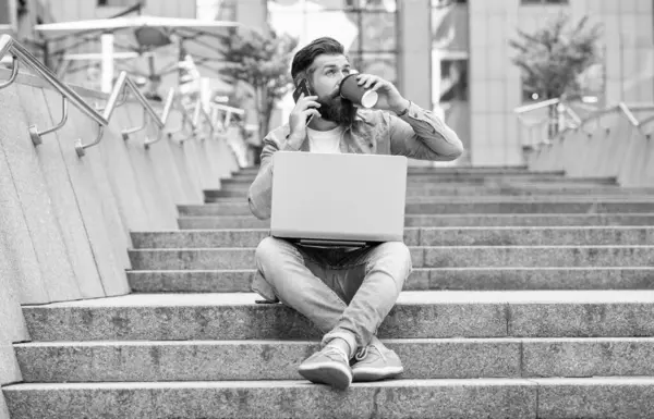 Açık havada serbest iletişimi olan tam boy bir adam. Serbest çalışan bir adam telefonda konuşuyor. Dizüstü bilgisayarında serbest iletişimi olan bir adam. Dışarıda serbest çalışan bir adam var..