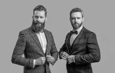 Gri renkte takım elbise ve papyon giyen şık erkek giyimli iki smokinli beyefendi..