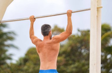 Kas kasları ve trisepsler. Güçlü bir atlet. Adam yanaşıyor. Güçlü sırt kası olan kaslı bir sporcu. Spor barfiks egzersizi. Spor eğitimi. Sporcu adam egzersiz yapıyor..