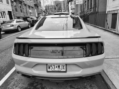 New York City, ABD - 10 Mart 2024: 2018 Ford Mustang sarı spor arabası, arka manzara.