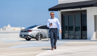 Şirket işi. Dışarıdaki telefonda iş adamı sohbeti. İş adamı telefonda sohbet ediyor. Akıllı telefon kullanan bir iş adamı. İnternette yakışıklı bir iş adamı sohbeti. İş adamı yürüyor. İş görüşmeleri.