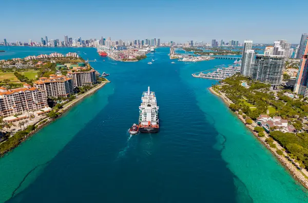 Miami, Florida, ABD - 20 Mart 2025: kargo gemisi ve römorkör. Kargo gemisi. Miami limanı. Monrovia konteynırı gemisi. Kargo Limanı Kaşif konteynır gemisi, deniz taşımacılığı.