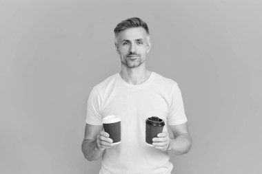 Olgun bir adam mavi üzerine kafeinsiz kahve fincanı seçer. Sabah kahvesi vakti. Yaşam tarzı konsepti. Kafeinsiz içiyorum. Çay içen adam. Sıcak bir sabah, rahatla. Kahveci adamla kahve molası. Boşluğu kopyala.