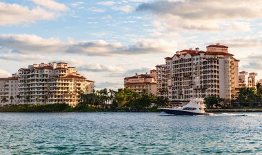 Marinaya yüzen bir tekne. Fisher Adası 'nda lüks bir yat teknesi. Yaz tatili. Fisher Adası konut binası ve lüks yat teknesi. Miami Fisher Adası Panorama Manzarası.