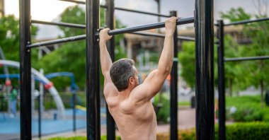 Güçlü bir atlet. Adam yanaşıyor. Güçlü sırt kası olan kaslı bir sporcu. Spor barfiks egzersizi. Spor eğitimi. Sporcu adam egzersiz yapıyor. Egzersizi kaldır..