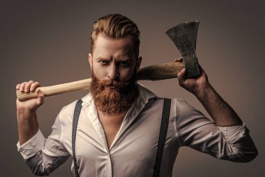 Erkeksi enerji. Retro tarzı. Yakışıklı ve karizmatik. Erkeksi adam. Baltası gri renkte olan sakallı bir adamın erkekliği. Sakallı ve bıyıklı, beyaz, vahşi bir adam. Olgunluğun sembolü.