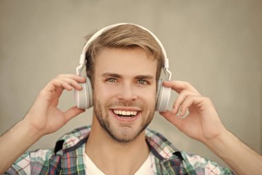 Milenyum adamı açık havada müzik dinler. Modern yaşam tarzı. Öğrenci hayatı. Kulaklıkla müzik dinle. Milenyum kuşağı sesi dinler. Müzik aşığı yaşam tarzı. Rahatlatıcı melodiler. Yüz resmi.