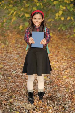 Sonbahar parkında elinde okul kitabı olan genç bir kız. Açık hava okulunda kız eğitimi. Bilgi ve eğitim. Bilgi toplama günü. Sonbahar Tutma Kitabı 'ndaki kız. Eğitim kitabı. Okula geri dön..