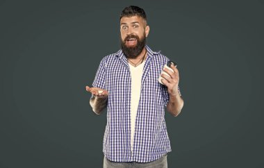 Şaşırdım, olgun adam gri arka planda vitamin kavanozu tutuyor..