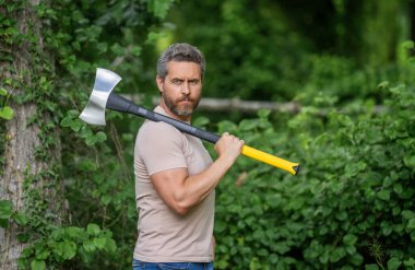 Oduncu baltası. Ağaç kesen baltalı adam. Erkeksi vahşi adam. Oduncu dışarıda kamp yapıyor. Acımasız oduncu. Vahşilik ve erkeklik. Baltalı İspanyol oduncu adam. Orman temizliği.