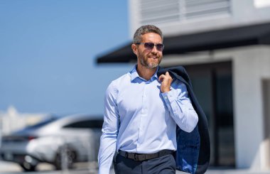 Dışarıda başarılı bir iş adamı. İşadamı tarzı bir portre. Başarılı bir iş lideri. İş adamının iş başarısı. İş adamı liderliği. Üst düzey yönetici, avukat. Güneş gözlüklü zengin adam..