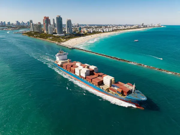 Yük konteynırı kargo gemisine yüklendi. Limandan ayrılan hava görüntülü kargo gemisi. Kargo işi. Konteyner gemisi. Nakliye lojistiği. Ticari nakliye. Kargo gemisi denizde, hava manzaralı..