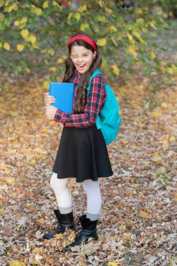 Bilgi toplama günü. Sonbahar Tutma Kitabı 'ndaki kız. Eğitim kitabı. Okula dönelim. Sonbahar parkında elinde okul kitabı olan genç bir kız. Açık hava okulunda kız eğitimi. Bilgi ve eğitim. Kendi kendine çalışma.
