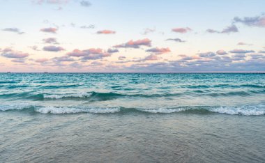Deniz ufkuyla gökyüzü. Deniz doğarken sakin ufuk manzarası. Deniz manzarasında romantik yaz tatili gündoğumu. Deniz ufku manzarası. Yaz tatilinde bulutlu gökyüzü ve deniz manzarası. Deniz dalgaları.
