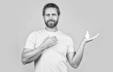 Burun tıbbı damlaları olan bir adam görüntüsü. Burun tıbbı olan adam sarıda izole edilmiş. Geçmişinde burun tıbbı olan bir adam. Stüdyoda burun tıbbı olan bir adam..