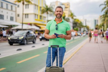 40 'lı yılların yolcusu. Yaz tatilindeki turist. Yaz gezisi için seyahat valizleri. Yaz turu. Gezgin yaz tatilinin tadını çıkar. Latin turist şehir caddesinde. Çantası ve pasaportu olan bir turist..
