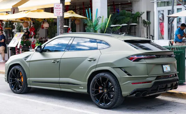 Miami, Florida, ABD - 08 Aralık 2024: Luxur yeşil renkli Lamborghini Urus S tipi spor araba. Lamborghini Urus 'un arabası dışarıda park halinde. Lamborghini Urus, yan görüş. 2024 Lamborghini Urus S SUV arabası.