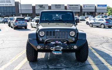 Park Ridge, Illinois, ABD - 29 Ağustos 2024: Jeep Wrangler 2015 SUV arabası. Jeep Wrangler SUV tipi lüks bir araba. Jeep Wrangler 'ın arabası dışarıda park yerinde. Jeep Wrangler, ön manzara..