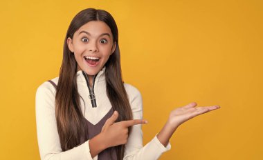 sarı arka planda uzun saçlı bir çocuk. ürün sunuluyor.