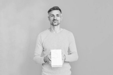 Randevu için romantik bir hediye. Erkekler günü için hediye. 14 Şubat 'ta olgun bir adam. Adam Sevgililer Günü için hediye kutusu verdi. Sevgililer günün kutlu olsun. Erkekler günü. Aşık bir adam maviden soyutlanmış. Hediye alışverişi..