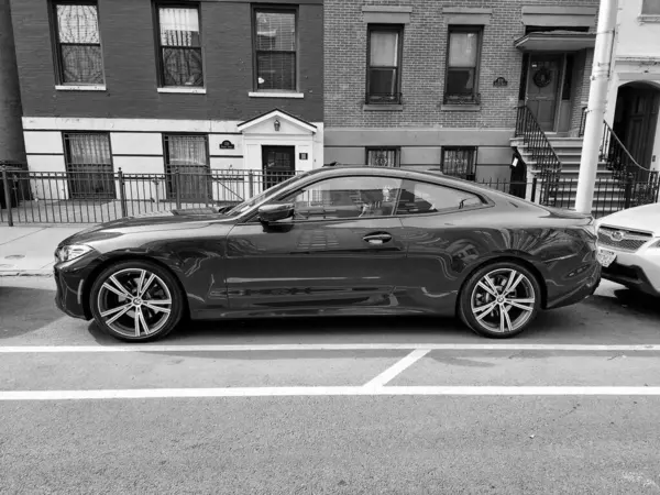 New York City, ABD - 27 Şubat 2024: BMW 4 lüks araba caddeye park edilmiş, yan manzara.