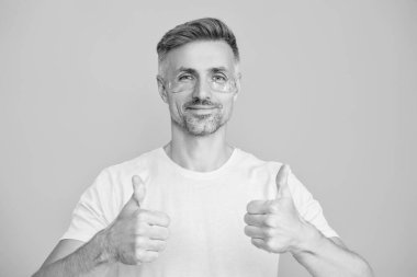 Kırışıklık önleyici göz bandı olan adam mavi üzerine izole edilmiş. Yenilenme etkisi. Kozmetoloji. Göz altı kırışıklık önleyici krem sürmüş olgun bir adam. Yüz güzelliği cilt bakımı. Susuz kalma..