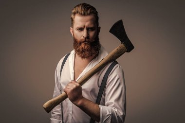 Yakışıklı ve karizmatik. Erkeksi adam. Baltası gri renkte olan sakallı bir adamın erkekliği. Sakallı ve bıyıklı, beyaz, vahşi bir adam. Erkeksi enerji. Retro tarzı. Klasik kuaförlük.