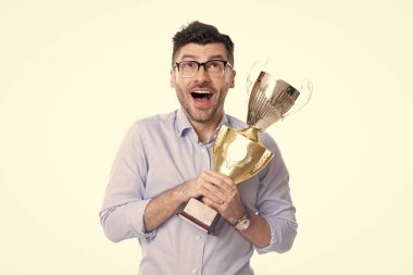 Gözlüklü başarılı bir iş adamı şampiyonluk kupasını tutuyor. İş ödülü ve başarı. İşadamı kazandı. İş başarısı. İş adamı. Beyazlar arasında başarılı bir toplantı. Şampiyonluk.